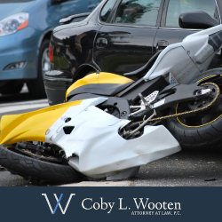 Damaged motorcycle lying on ground after being hit by car